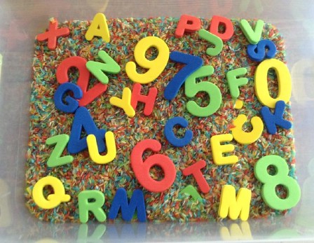 Teach your kids about letters and numbers in a sensory rice bin.