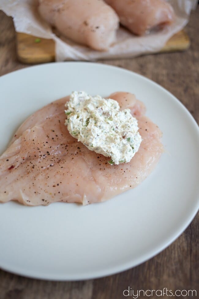 Filling the chicken breasts with flavored cheese.