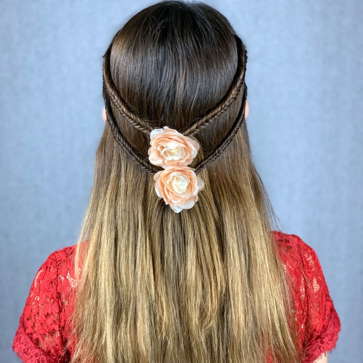 Fresh Spring Half Up Half Down 2 A woman with a half-up half-down braided hairstyle adorned with a coral flower clip, capturing the essence of spring